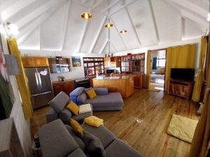 Il comprend un salon avec un canapé et une cuisine. dans l'établissement TAHITI - Vaiparaoa Villa, à Punaauia