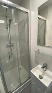 a bathroom with a glass shower and a sink at Westminster Guest House in Oxford
