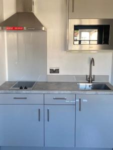 a kitchen with white cabinets and a sink at Westminster Guest House in Oxford