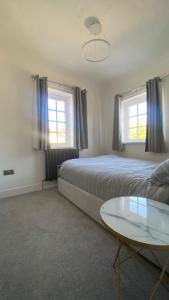 1 dormitorio con 2 camas y mesa de cristal en Westminster Guest House en Oxford