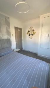 a bedroom with a bed with a blue striped sheet at Westminster Guest House in Oxford