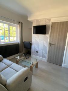 a living room with a white couch and a television at Westminster Guest House in Oxford