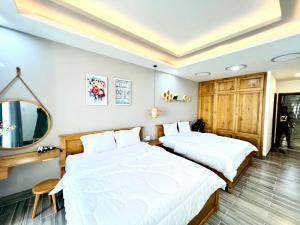 une chambre avec deux lits et un miroir dans l'établissement 1A/45 Hồ Quý Ly, à Vung Tau 22 autres photos