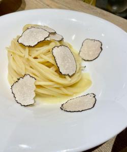un plato blanco de pasta con carne. en Podere San Giorgio, en Palaia