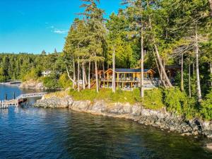 a house on the shore of a body of water at Kingfisher Manor in Sooke