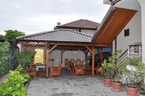 a pergola with chairs and tables on a patio at Guest House Miranda in Ohrid