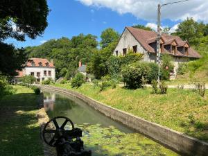 a canal in front of a building and a house at Chambre indépendante au calme avec parking privé in Souvigny-de-Touraine