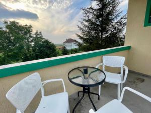 a table and chairs on a balcony with a view at Madigan's Hotel in Kosovo Polje