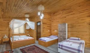 um quarto com 2 camas num chalé de madeira em Flora Pansiyon Çıralı em Kemer