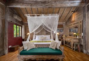 1 dormitorio con 1 cama con dosel en Heart of Bali Villa, en Ubud