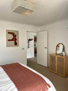 a white bedroom with a bed and a mirror at Waterfront Sub-Penthouse with Beach View in Geelong +21 photos