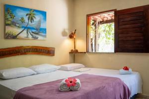 日若卡－迪熱里科阿科阿拉的住宿－Pousada & Restaurante Flambaião，一间卧室配有两张鲜花床。