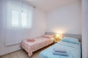 two beds in a small room with a window at Holiday house with a parking space Jadrija, Sibenik - 20641 in Šibenik