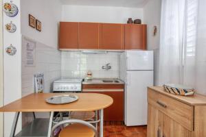 a small kitchen with a table and a white refrigerator at Holiday house with a parking space Jadrija, Sibenik - 20641 in Šibenik