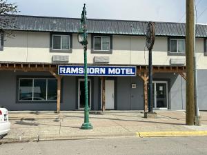 a street sign on a pole in front of a building at RAMSHORN MOTEL in Lumby