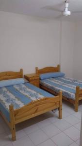 2 camas de madera en una habitación con suelo blanco en قرية جامعة القاهرة الكيلو 44 الساحل الشمالى 10, en Dawwār Abū Maḩrūs