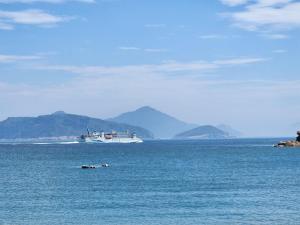 a large boat in the water with mountains in the background at Eternal Seaside House in Nangan