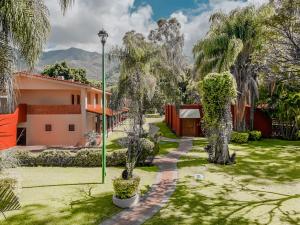 un jardín con árboles y una casa en Real de Chapala en Ajijic