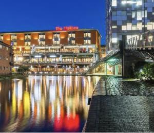 a building next to a river in front of a building at Apartments Near university in Birmingham