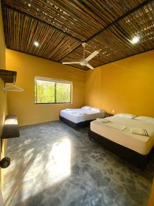 - 2 lits dans une chambre aux murs jaunes dans l'établissement Bio Casa Inusual, à Girardot