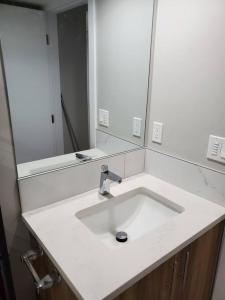 a white bathroom sink with a large mirror at Lovely Suite 2 Bedrooms in Airdrie