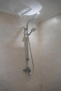 a shower with a shower head in a bathroom at Duplex La rose neuf et elegant in Sidi Bouzid