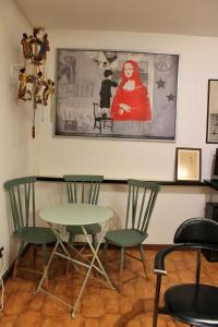 a table and chairs in a room with a painting at Jardim do Morro Places in Vila Nova de Gaia