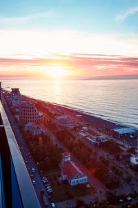 an aerial view of a city and the ocean at sunset at PANORAMA Center Suite in Batumi