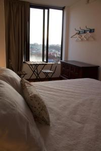 a bedroom with a bed and a large window at Jardim do Morro Places in Vila Nova de Gaia