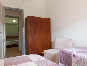 1 dormitorio con 2 camas y armario de madera en Artemisa en Piriápolis