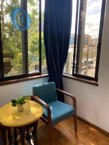 a blue chair and a table in a room with a window at Jardim do Morro Places in Vila Nova de Gaia
