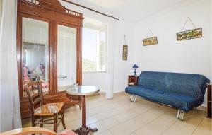 a living room with a blue couch and a table at Cozy Apartment In Ghisoni With Kitchen in Ghisoni