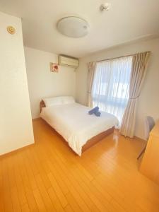 1 dormitorio con cama y ventana grande en 田端民泊ー田端ハウス en Tokio