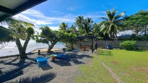 a backyard with chairs and a picnic table and the beach at TAHITI - Motu Nono Beach View 