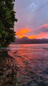 a sunset on the shore of a body of water at TAHITI - Motu Nono Beach View 