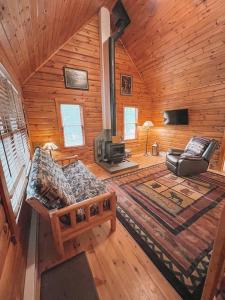 a log cabin with a couch and a fireplace at Mountain-Top-Hideaway Stay in a log cabin on a private rd! Swim, hike, explore a true mountain experience in North Blenheim