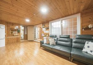 Il comprend un salon avec un canapé et une cuisine. dans l'établissement Jeju Haepoomdal Pension, à Jeju