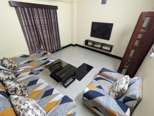 a living room with a bed and a tv at Rainagar rajbari in Sylhet