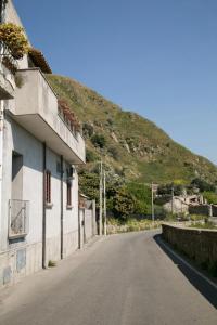 eine leere Straße neben einem Gebäude mit einem Berg in der Unterkunft A Casitta a pochi km da Taormina in Calatabiano