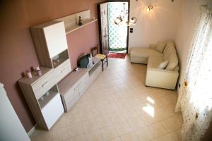 uma sala de estar com uma televisão e um sofá em A Casitta a pochi km da Taormina em Calatabiano