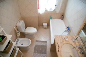 uma casa de banho com um lavatório, um WC e uma banheira em A Casitta a pochi km da Taormina em Calatabiano