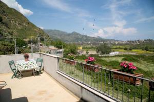 eine Frau auf einem Balkon mit Blick auf das Tal in der Unterkunft A Casitta a pochi km da Taormina in Calatabiano