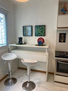 una cocina con barra y dos taburetes. en Aconchego e Estilo, ap com jacuzzi compartilhada, en Salvador