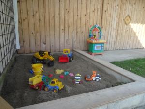 a sandbox with toys in the dirt in a backyard at Bachtelhuber-Hof in Teisendorf