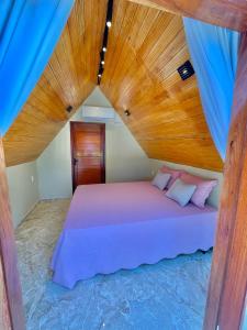 a bedroom with a bed with a wooden ceiling at Pousada Vale da Neblina in Ubajara
