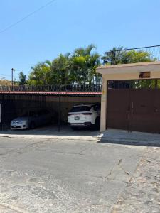 two cars parked in front of a garage at CONDOMINIO PALMEIRAS in Acapulco