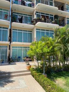 a large apartment building with palm trees in front of it at CONDOMINIO PALMEIRAS in Acapulco