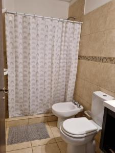 ein Bad mit einem WC und einem Duschvorhang in der Unterkunft Confortable Departamento Salta in Salta