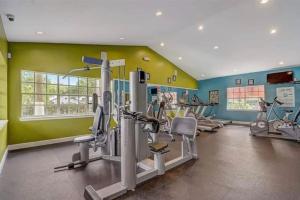 a gym with several tread machines in a room at Cozy & spacious 2 BR / 2 BA condo in Kissimmee