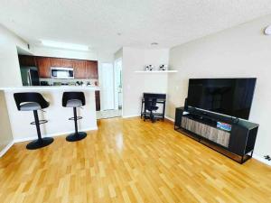 a living room with two stools and a flat screen tv at Cozy & spacious 2 BR / 2 BA condo in Kissimmee
